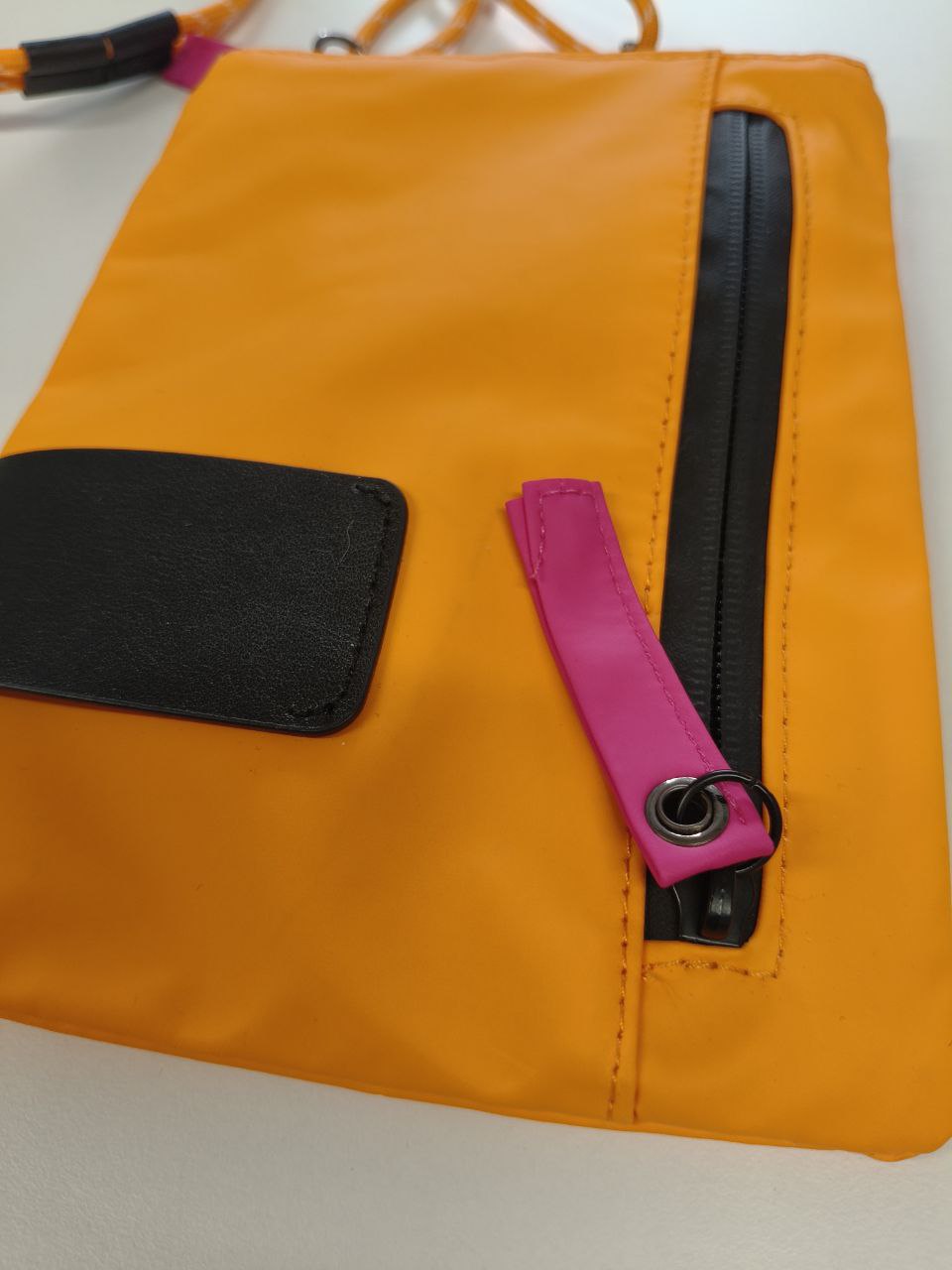 Borsetta arancione in materiale tecnico e ecopelle con tracolla in corda e tasche